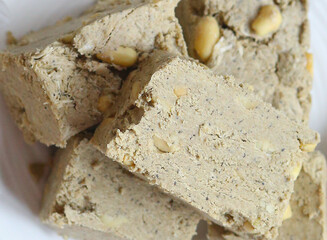 Flat lay a eastern sweets, halva on a white plate and a wooden background. Food. Delicious. Homemade sweets concept.