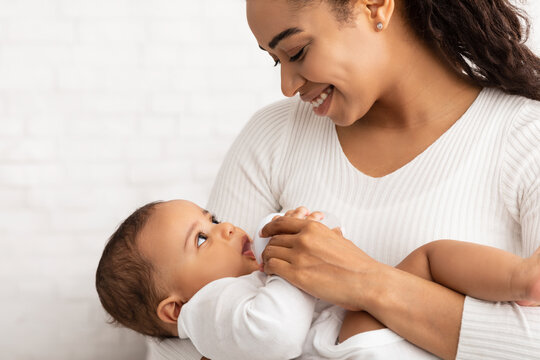 Happy Black Mother Feeding Newborn Baby Giving Bottle, White Background