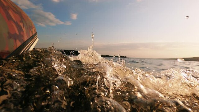 Water wave bubbles view. Boat riding. Speed journey. Rubber motor ship going fast on river surface blur sunlight flacks reflection blue sky horizon.