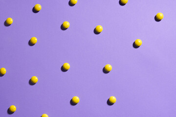 Texture purple background with yellow chocolate candies