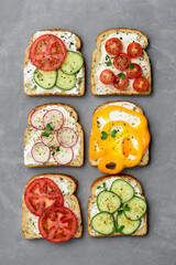 Healthy vegetarian sandwiches with vegetables - yellow pepper, tomato, cucumber and radish. Cream cheese and microgreens