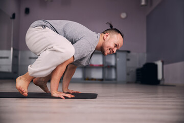 Fototapeta premium Positive delighted man standing in yoga asana