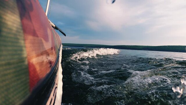 Defocused river view. Boat riding. Enjoying speed. Close nature. Rubber motor ship going fast on water surface creating waves and bubbles blur sunlight flacks sky horizon.