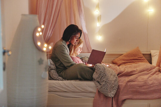 Mom Reading A Bedtime Story To Her Daughter