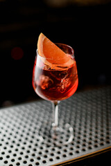 close-up view of beautiful wine glass with bright cold iced drink decorated with citrus slice