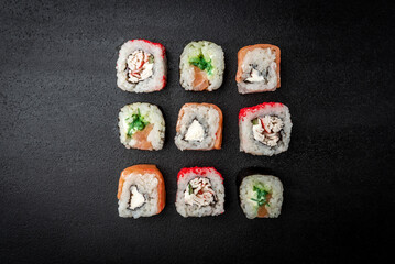 Sushi rolls on black background. Japanese food.