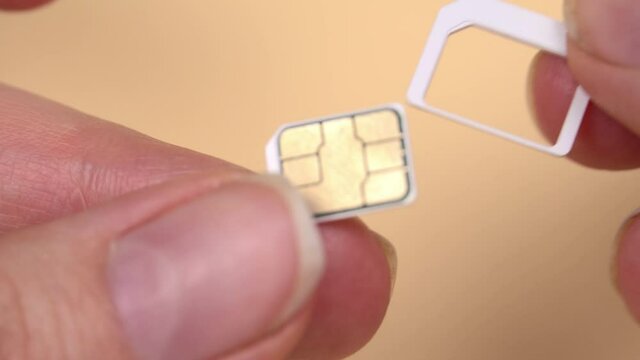 The envelope with the new SIM card was delivered. A woman's hand takes out a new SIM card for a mobile phone from the tray.