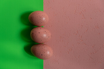 Three Easter eggs on two backgrounds, pink and green background