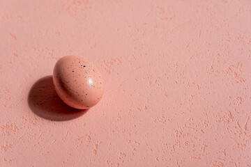 One pink Easter eggs on a pink background