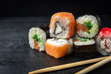 Sushi rolls on black background. Japanese food.