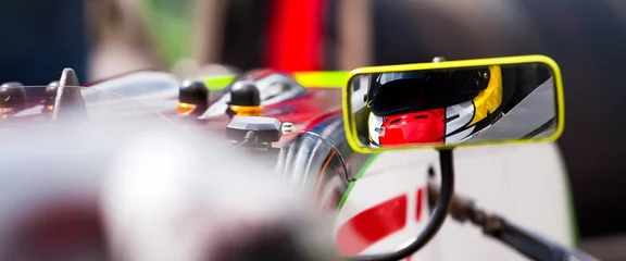 Poster Im Rahmen Ein Blick auf einen Fahrer im Rückspiegel seines Supersportwagens, der bereit ist, das Rennen zu starten © danieleorsi