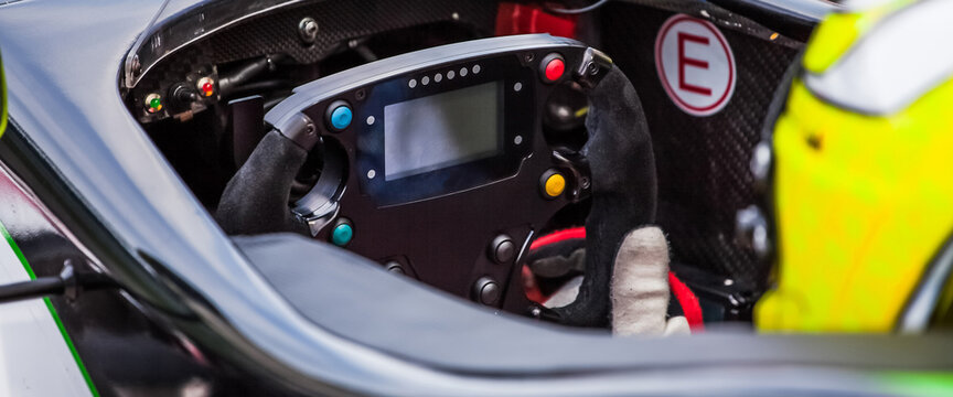 A Driver Holds The Steering Wheel Of His Supercar