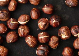 Obraz premium Roasted dried hazelnuts on iron pan.