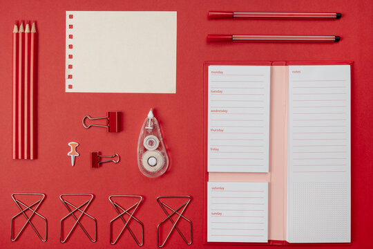 Office accessories for desk in red, weekly task pad, corrector, paper clips,