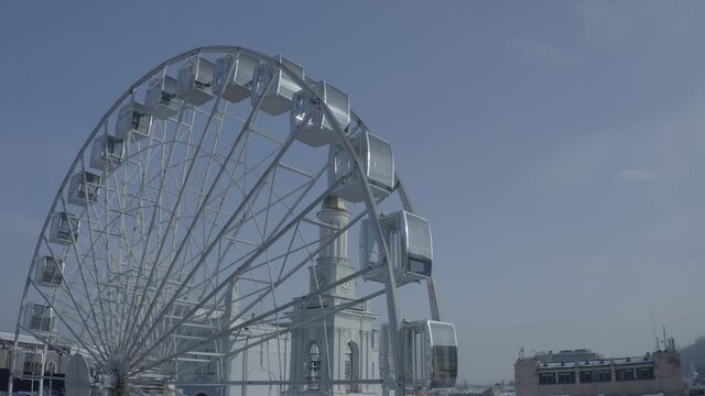 Kiev. Drone video. The big white Ferris wheel and tourists walking in the center of Kontraktova Square in the Podolsk district of Kiev. Winter morning.