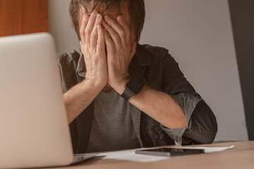 Disappointed freelancer with head in hands crying