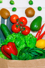 Paper bag with different groceries on white background