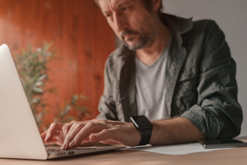 Freelancer working on laptop computer at home office desk