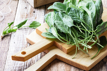 Fresh spinach on wooden board, plant based vegan food