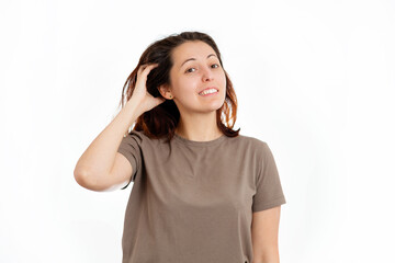 A young Caucasian woman is scratching her hair from dandruff and irritation. White background. The concept of hair care