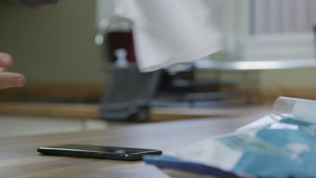 Sliding Close Up Of Male Hands Cleaning A Mobile Phone With Anti Bacterial Wipe