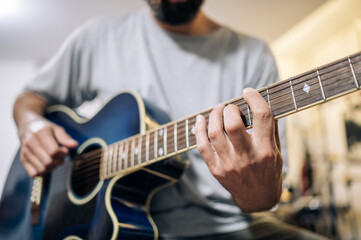 Fototapeta na wymiar Young man practicing acoustic guitar at home.Focus selective