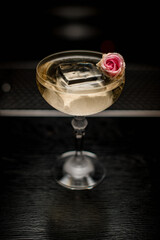 high angle view on glass with drink and ice cube decorated with pink flower