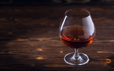 Glass of cognac or brandy on natural wooden background. Glass of whiskey. Alcohol drink on Bar...
