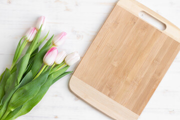 bouquet of light pink tulips with bamboo cutting board