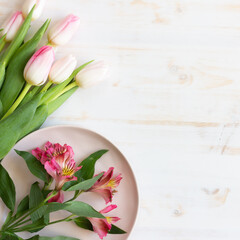 pink tulips on wooden background with Alstroemeria stem