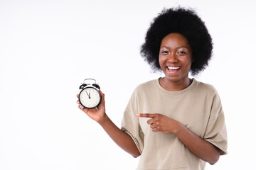 Happy african teenage girl pointing at clock isolated over white background