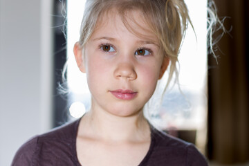 Portrait d'une jeune fille enfant blonde au yeux marron en lumière studio