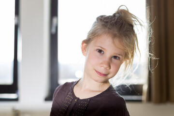 Portrait d'une jeune fille enfant blonde au yeux marron en lumière studio