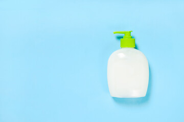 Pump bottle on blue background. Liquid soap, cosmetic dispenser bottle. Copy space. Hygiene concept.
