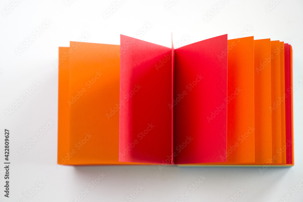 Poster overhead shot of a colorful notepad on a white surface