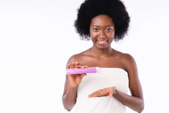 African-american Young Woman In Spa Towel Using Shower Gel In White Background