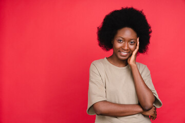 Fototapeta na wymiar Shy african girl in casual clothes isolated in red background