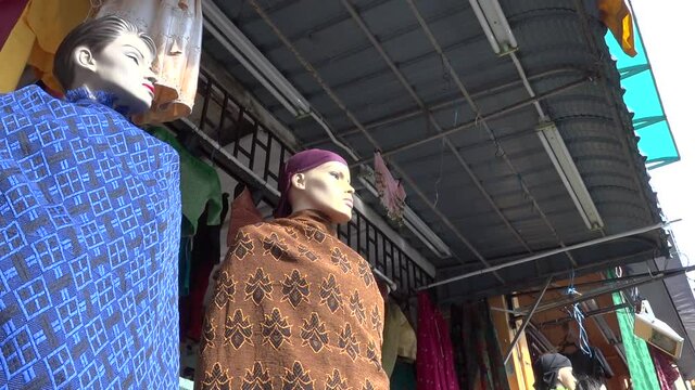 Two mannequins with clothes on them for saling in the front of indian street shop in Penang city.