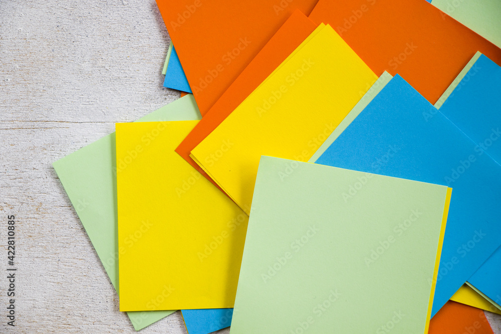 Poster overhead shot of colorful blank note papers on a white surface with space for your text