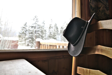 Fototapeta na wymiar A Cowboy Hat Hangs In a Rustic Cabin