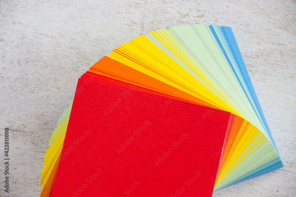 Poster overhead shot of a stack of colorful notepad on a white surface with space for your text