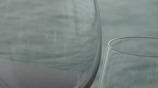 Two glasses reflect the ocean blue water in sailing moving action.