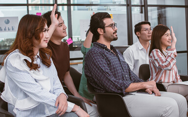 Fototapeta premium Group of people raising their hands and attending seminar