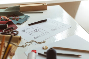 Designer sketches of women's bags on the desktop.