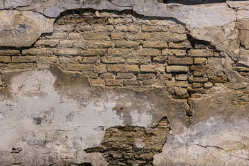 Old brick wall with modern plaster falling apart