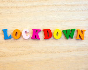 The word LOCKDOWN spelt with multi-colored wooden letter tiles.