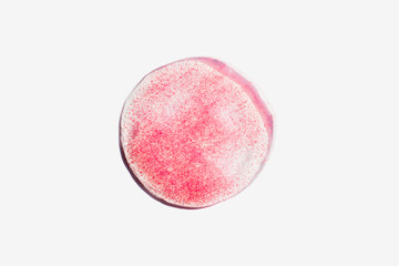 Pink transparent cosmetics drop on white background. Skincare scrub swatch with particles. Beauty concept