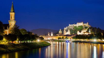 Salzburg city evening view. Cathedral, Old Town Altstadt, Evangelische Pfarrgemeinde Christuskirche Hohensalzburg castle illuminated at night. 