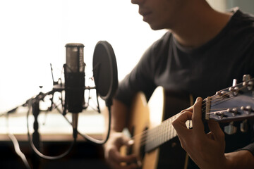 man playing spanish guitar and singing while recording it with a microphone. Home studio