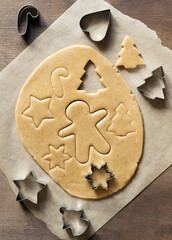 Rolled out dough for ginger biscuits. Slicing cookies with special metal moulds.